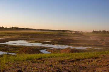 Heavy sand dust raised at an active sand quarry in the sun