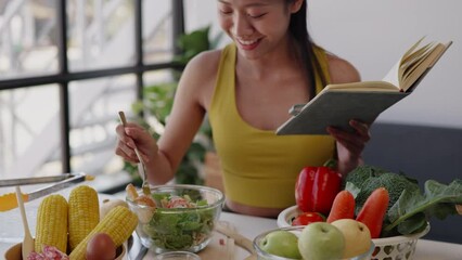 Healthy woman preparing and eating organic fruit and vegetable salad in kitchen for healthy lifestyle and reading a book - Powered by Adobe