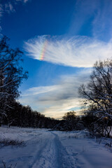 Cloud with rainbow effect on blue sky, vertical landscape