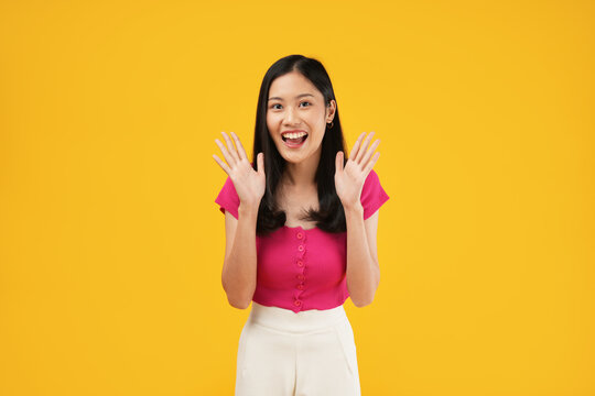 Excited asian woman shout out loud wow with hands on isolated background. Happy shocked face female wow promotion advertising concept. Isolated on yellow background - Powered by Adobe