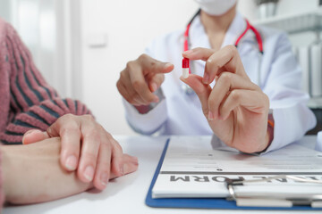 female doctor reassuring patient with comforting hand gesture, with model of the female...