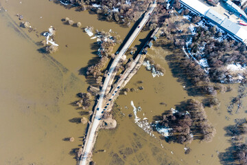 View from a great height of the river dam and the road running through the flooded area. A river...