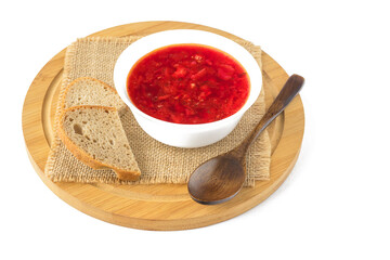 In a white bowl there is delicious fresh borscht soup with pieces of bread, isolated on a white background.