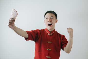 Excited face expression of Asian man wearing Cheongsam or Chinese traditional cloth while holding...