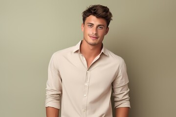 A smart and handsome young male model in a casual yet stylish outfit, capturing a laid-back and trendy look, against a solid light beige background.