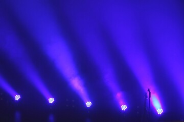 White and pink stage lights on a blue background for a concert