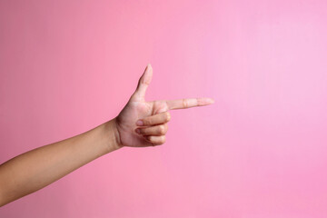 Hand pointing aside isolated on a pink background. It's you gesture - obrazy, fototapety, plakaty