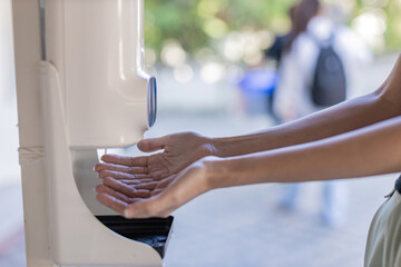 Hands under the automatic alcohol dispenser. Infection and hospitably concept. save and protect...