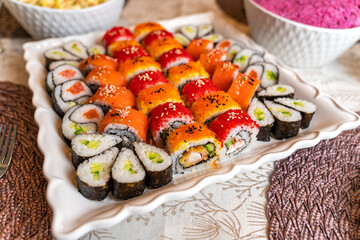 Assortment of rolls and sushi on a wooden board.