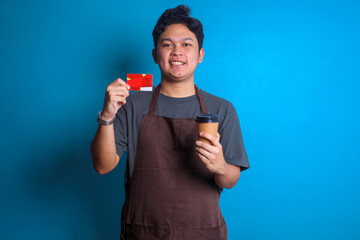 Asian young barista man holding a craft paper brown cup coffee to go and credit card as a payment