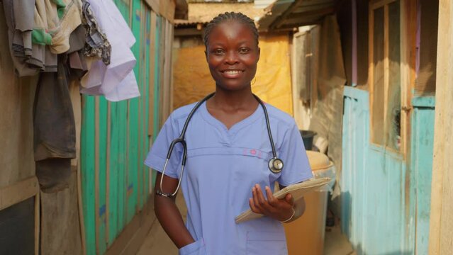 African black woman doctor nurse with blue coat lab and stethoscope smiling in front of camera standing in clinic hospital of undeveloped country of africa healthcare system , portrait of 