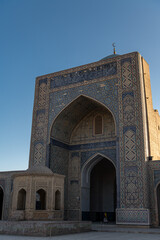 Fototapeta na wymiar View to Mir i Arab madrassa through old wooden carved door, Bukhara, Uzbekistan