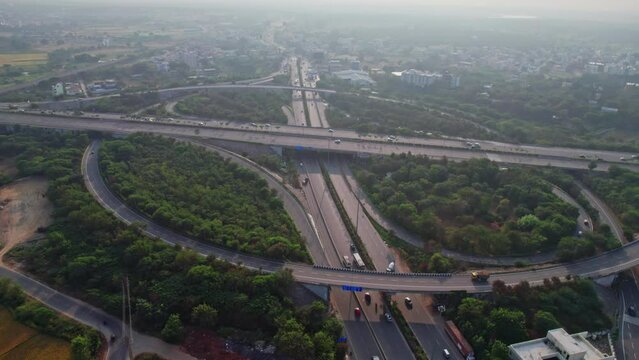 Aerial shot of elevated highway road junctions. The Intersecting freeway road overpass. Overhead Shot of nehru outer ring road Highway showing multiple Roads in Devatabowli, hyderabad, telangana