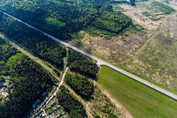 View from a great height of the intercity highway passing by fields and forests