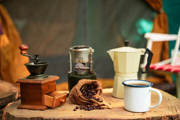selective focus of vintage coffee set on the old wooden table In front of the retro cabin tent,...