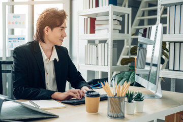 Businessman using laptop computer in office. Happy middle aged man, entrepreneur, small business owner working online.