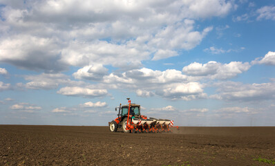 Fototapeta premium Tractor and seeder for sowing corn