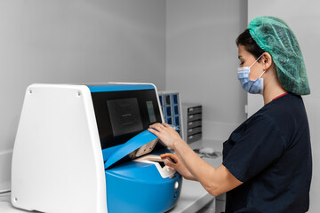 embryologist inserts fertilized egg into embryoscope. EmbryoScope for embryo culture. Time lapse...