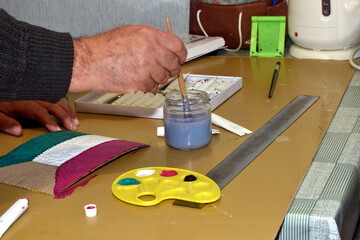 Artis 's work table with paint, politer, water.