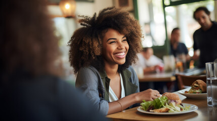Black afro American business woman having a friendly lunch with colleagues at a local cafe, she engages in casual conversation, fostering a positive and collaborative atmosphere