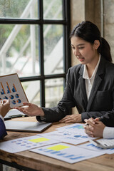 Young professional Asian accountant or financial analyst presents a financial report during a...