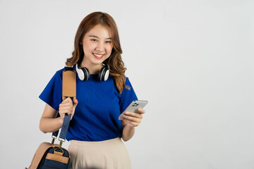 Asian schoolgirl holding bag and using smartphone on white background, education concept