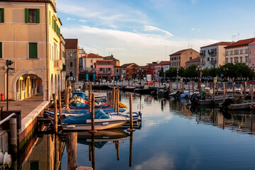 Scenic view of peaceful canal Vena at sunrise in charming town of Chioggia, Venetian Lagoon,...