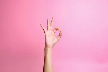 Foto op Aluminium Hand showing ok sign with fingers isolated over pink background. Hand gesture © Queenmoonlite Studio
