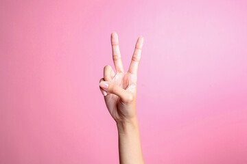 Hand showing two fingers isolated on pink background, victory and peace gesture - Powered by Adobe