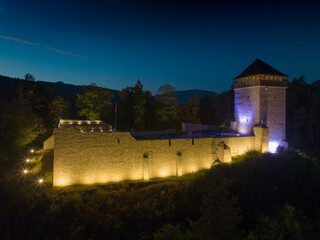 Wzgórze zamkowe Baszta w Muszynie i zamek po renowacji nocą. Widok na mury.