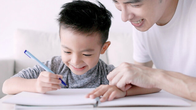 Young father checking homework helping  child  with study at home