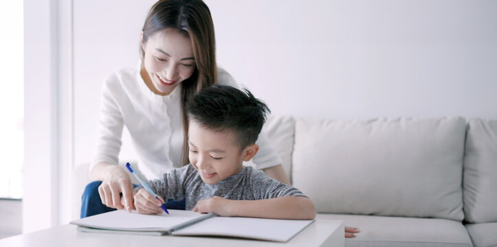 Young mother checking homework helping  child  with study at home