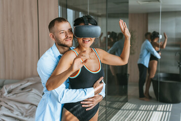 Couple with VR headset dancing, enjoying innovative entertainment technology