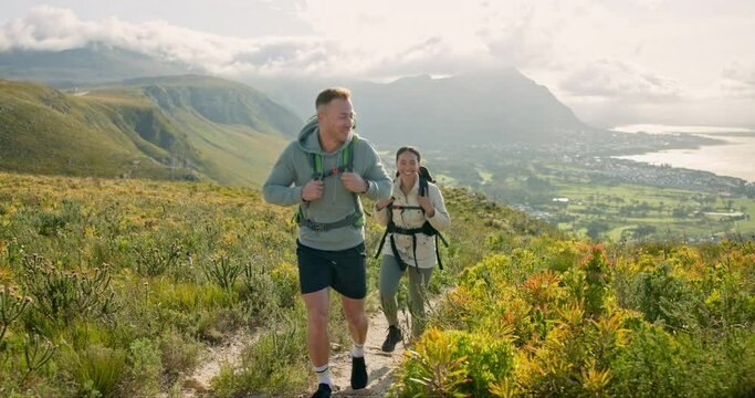 Couple of friends walking, hiking on mountain and travel for fitness, adventure or journey in nature for wellness. Young people trekking with backpack on a path or green hill for cardio and health