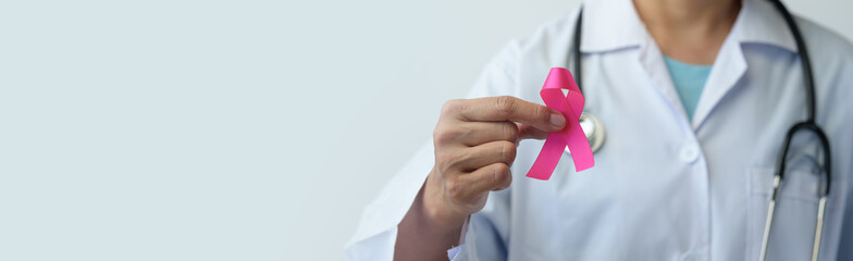 Breast cancer campaign Illustration of woman's hand in doctor's uniform and pink ribbon showing...