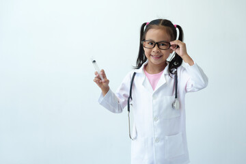 Smiling girl wearing glasses wearing a doctor's coat in medical practice Using a stethoscope and syringe for medical examination Standing on white background. Career concept. Planning for the future. - Powered by Adobe