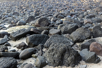 An abstract background of pebbles on the beach. Rocks texture and pattern with copy space for additional text.