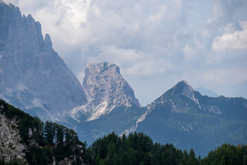 Scenic view of mountain peaks in untamed Julian Alps seen from summit Cima del Cacciatore, Monte Santo di Lussari, Friuli-Venezia Giulia, Italy. Wanderlust in remote Italian Alps in summer. Cloudy day