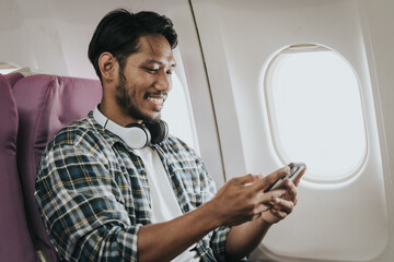 Asian male tourist enjoying airplane travel, traveling around the world on his own.