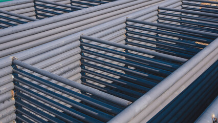 Pile of carbon steel roof beams stacked on the ground for metal construction material of industrial...