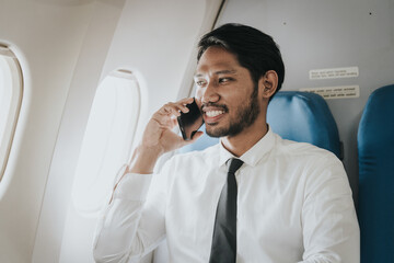 Asian businessman, possibly a stock market trader or investor, focused on his tablet while flying,...