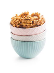 Peeled dried walnut kernels in bowl isolated on white background.