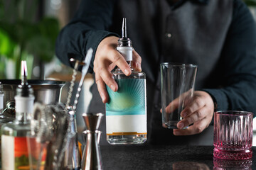 Bartender Holds A Bottle of Gin and Prepares To Make A Negroni Cocktail