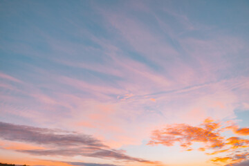 A beautiful sky tinted by the sun leaving vibrant shades of gold, pink, blue and multicolored. Clouds in the twilight evening and morning sky. Cloudy sky background in the evening and during the day.