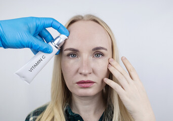 Vitamin A, Retinol, Niacinamide, Vitamin C. Girl smears her face with antioxidant anti-wrinkle...