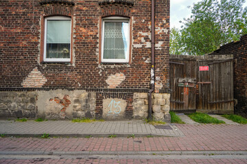 Fototapeta na wymiar old vintage damaged building facade , Polish brickwall facade entrance 