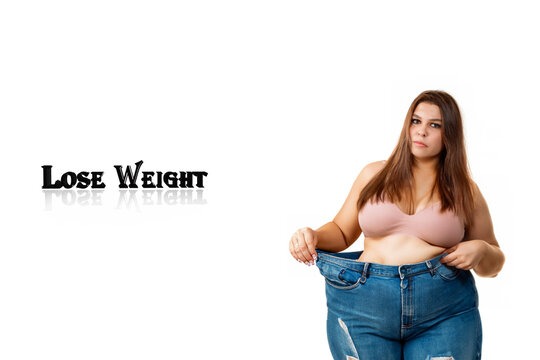 the girl is losing weight. fat girl in a pink top and wide jeans stands on a white background, weight loss concept