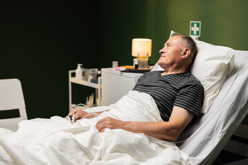 A happy old man lying in a hospital bed who sees his son.