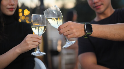 Shot of young couple toasting champagne on blurred Night city light background.