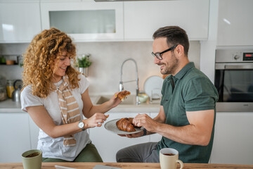 Fototapeta na wymiar Adult couple have breakfast in the kitchen at home morning routine